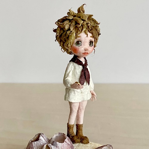 貝殻の上に佇む和紙人形の完成作品。静かな旅を思わせる物語性のある造形。(表情)
