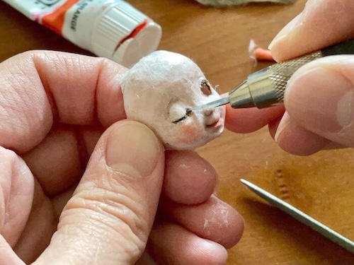 和紙人形の顔制作。和紙の繊維を使ってまつ毛を貼り付けている工程。