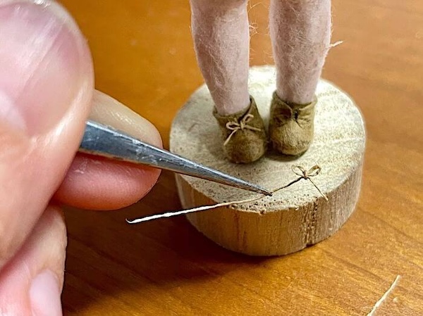 和紙人形の足元の靴紐の制作工程の様子