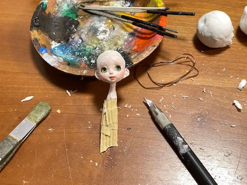 顔が完成した和紙人形に胴体を取り付ける製作途中の様子