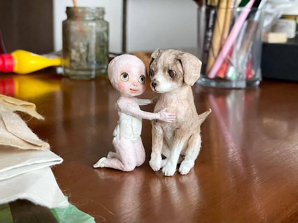 少年と犬の和紙人形を仮組みし、寄り添う構図を確認している制作途中のシーン。
