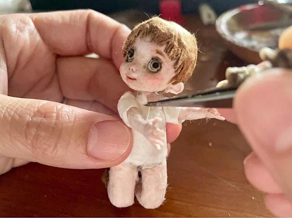 少年のディテール、服を製作。腕にT
シャツの袖口を巻きつけ貼っているところ。