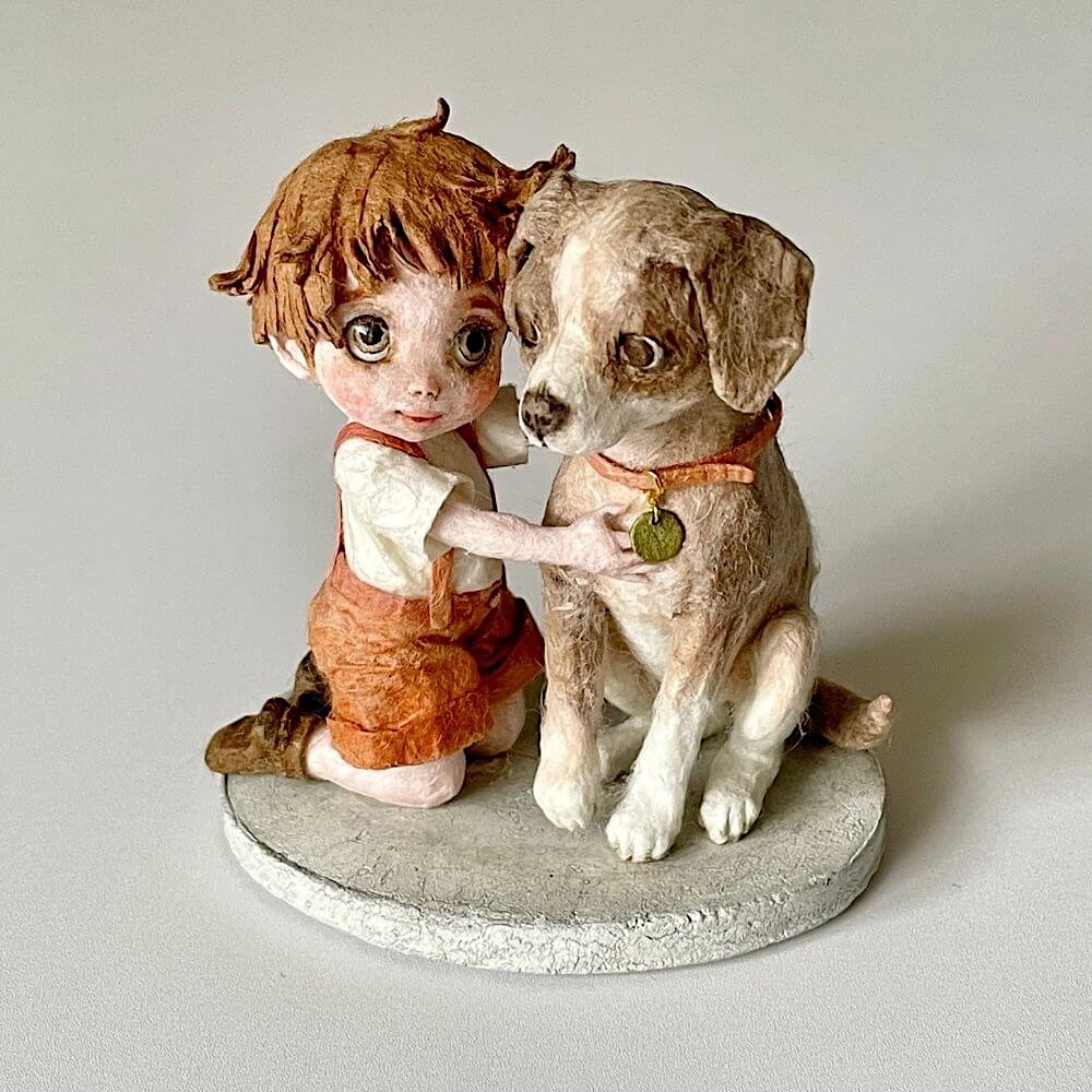 少年と犬が向かい合い、優しく触れ合う瞬間を切り取った和紙人形『ずっと大切な君へ』の別角度ショット。立体感と細部の造形がわかるミニチュア作品。