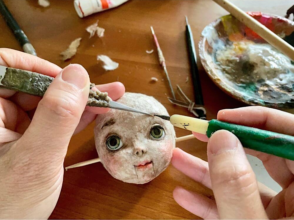 顔の最終工程として眉毛を張ってるところ