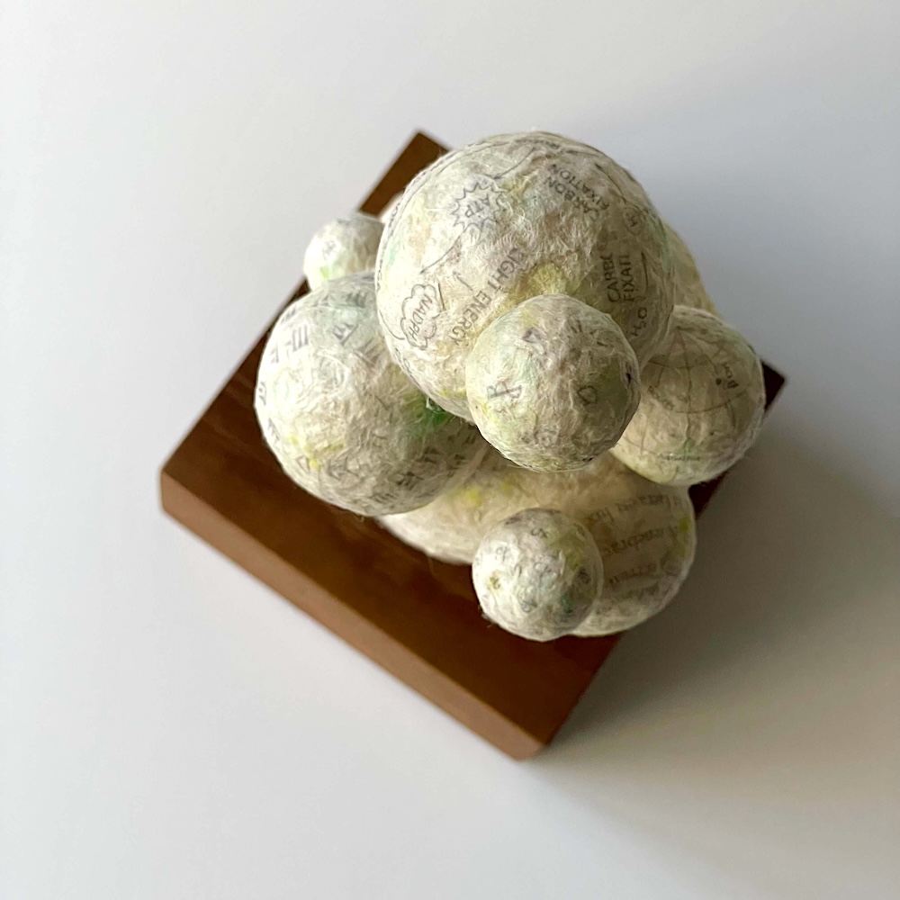 頭上に思考の球体が浮かぶロクタ紙の創作人形「頭の中に浮かぶもの」(俯瞰図)
