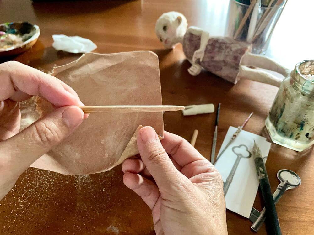 編み針と木材を加工して、和紙人形が持つ鍵を製作しているところ