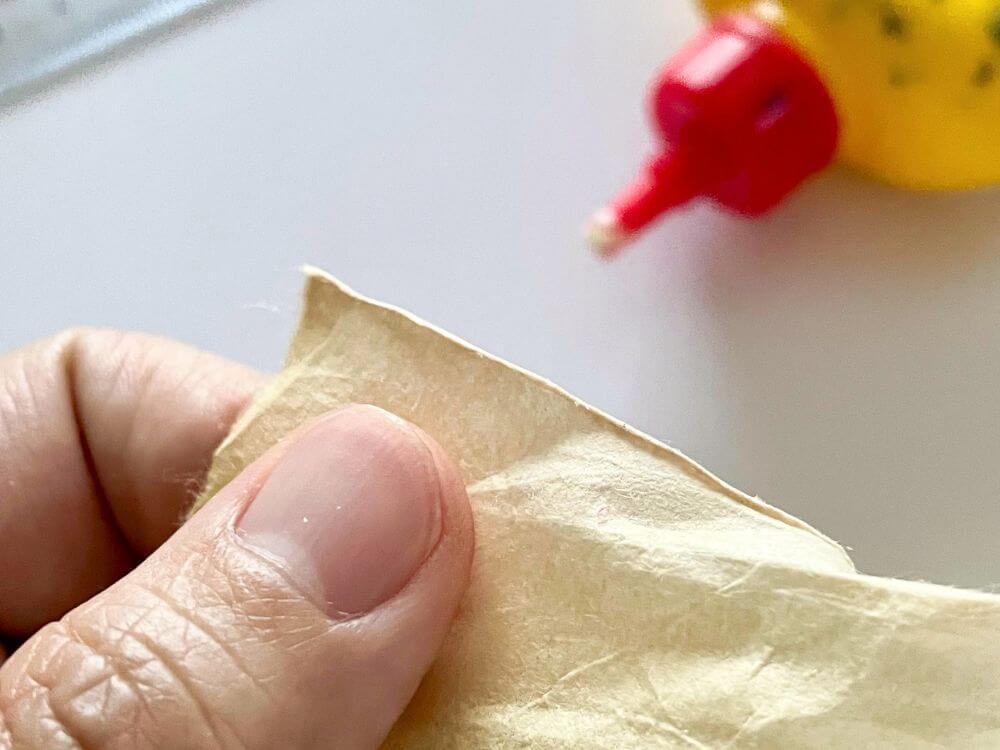 クリーム色の和紙を折り曲げて花芯のパーツを作る工程