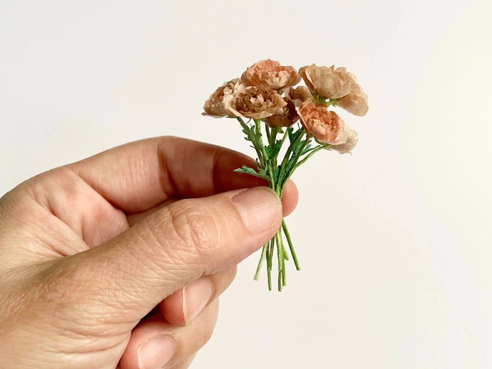 完成したミニチュアラナンキュラスの花束を手に持った様子